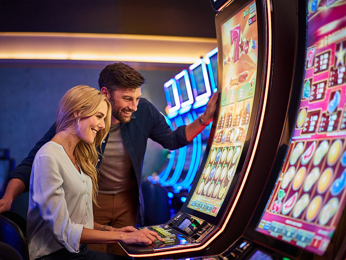 Mann und Frau am Spielautomaten im Casino
